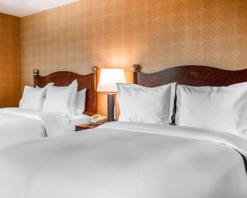 
a hotel room with two beds and two lamps at The Woodlands Inn, Ascend Hotel Collection in Wilkes-Barre
