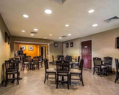 Quality Inn & Suites NJ State Capital Area في Morrisville: مطعم فيه كراسي وطاولات وساعة على الحائط
