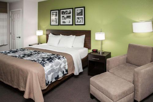 a hotel room with a bed and a chair at Sleep Inn & Suites Harrisburg - Hershey North in Harrisburg