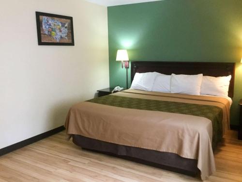 a hotel room with a bed and a green wall at Econo Lodge Harrisburg - Hershey in Harrisburg