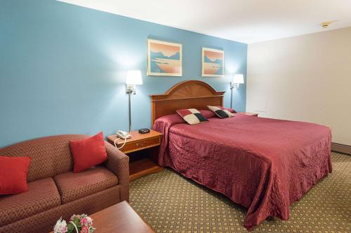 a hotel room with a bed and a couch at Rodeway Inn Milford - I-84 in Milford