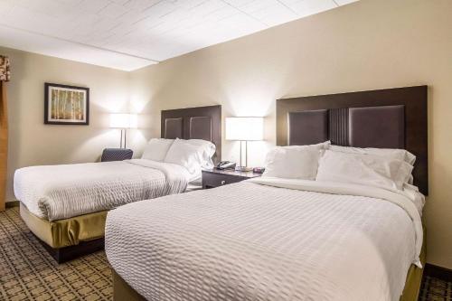 a hotel room with two beds and two lamps at Clarion Inn Pittsburgh Cranberry in Cranberry Township