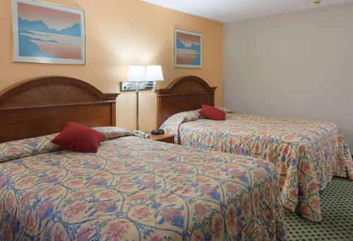 a hotel room with two beds with red pillows at Rodeway Inn Milford - I-84 in Milford