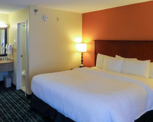 a hotel room with a large white bed with a lamp at Quality Inn Cranberry Township in Cranberry Township