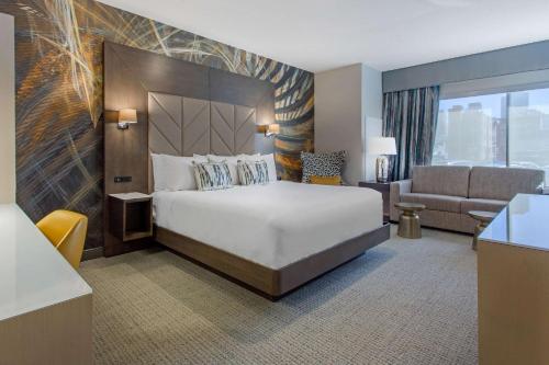 フィラデルフィアにあるCambria Hotel Philadelphia Downtown Center Cityのベッドとソファ付きのホテルルーム