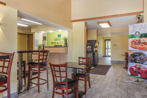 HarmarvilleにあるQuality Inn & Suites Pittsburgh Harmarvilleの部屋にテーブルと椅子があるレストラン