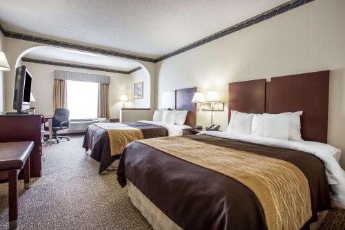 a hotel room with two beds and a television at Comfort Inn & Suites FtJackson Maingate in Columbia