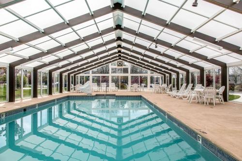 an indoor swimming pool with a glass ceiling and a swimming poolvisor at Quality Inn and Suites Newport - Middletown in Middletown