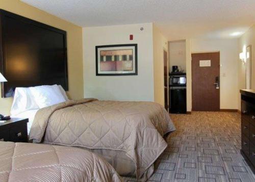 a hotel room with a bed and a bathroom at Quality Inn & Suites Greenville near downtown in Greenville
