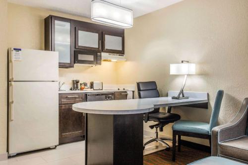 a kitchen with a table and a refrigerator and chairs at MainStay Suites Greenville Airport in Greer
