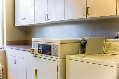 a kitchen with white cabinets and white appliances at Sleep Inn Airport in Columbia