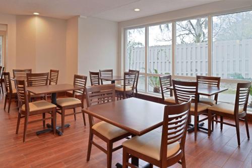 a dining room with tables and chairs and windows at Sleep Inn Beaufort near MCAS in Beaufort