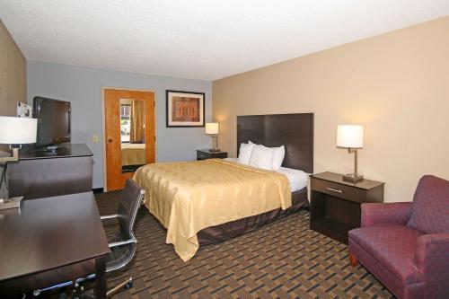 a hotel room with a bed and a chair at Quality Inn Clinton - Laurens I-26 in Clinton