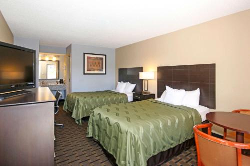 a hotel room with two beds and a flat screen tv at Quality Inn Clinton - Laurens I-26 in Clinton