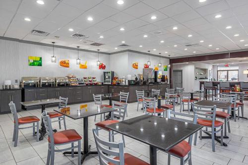 a dining room with tables and chairs in a restaurant at Quality Inn & Suites Greenville - Haywood Mall in Greenville