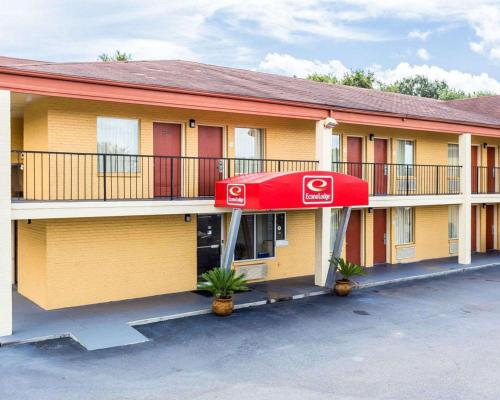 a hotel building with a red awning in a parking lot at Econo Lodge Coliseum in Charleston