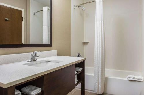 a bathroom with a sink and a bath tub at Comfort Suites at Isle of Palms Connector in Charleston