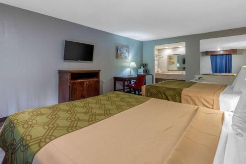 a hotel room with two beds and a flat screen tv at Econo Lodge Aiken Central in Aiken