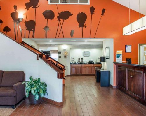 a lobby with orange walls with a staircase and a kitchen at Sleep Inn North Charleston Ashley Phosphate in Charleston