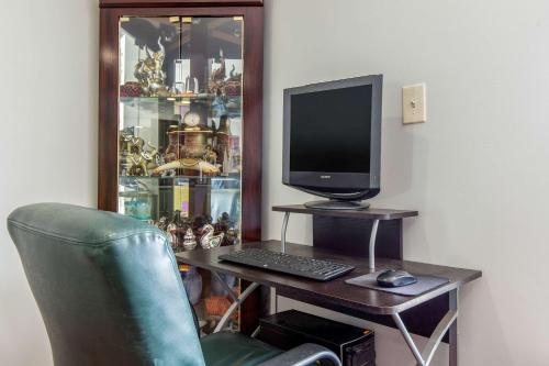 a desk with a computer and a monitor and a chair at Econo Lodge Aiken Central in Aiken