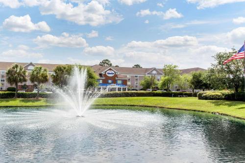 a fountain in a pond in front of a building at Studio 6 Myrtle Beach, SC in Myrtle Beach
