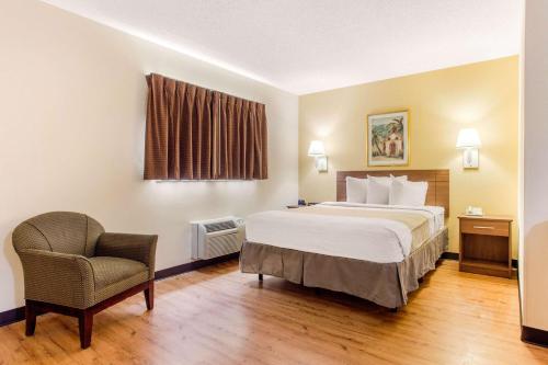 a hotel room with a bed and a chair at Studio 6 Myrtle Beach, SC in Myrtle Beach