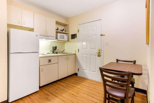a kitchen with a table and a white refrigerator at Studio 6 Myrtle Beach, SC in Myrtle Beach