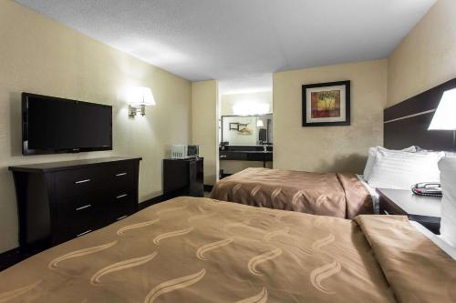 Una habitación de hotel con dos camas y un televisor de pantalla plana. en Quality Inn Goose Creek - Charleston, en Charleston