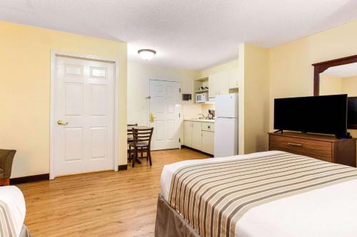 a hotel room with a bed and a kitchen at Studio 6 Myrtle Beach, SC in Myrtle Beach