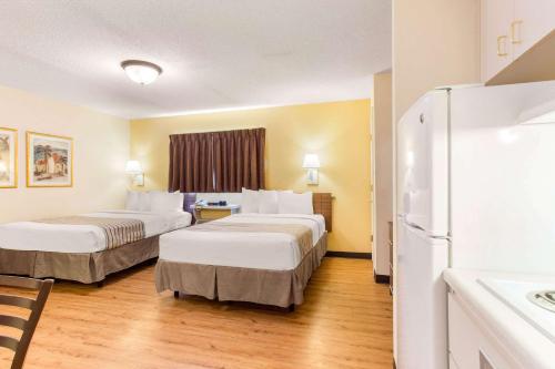 a hotel room with two beds and a refrigerator at Studio 6 Myrtle Beach, SC in Myrtle Beach