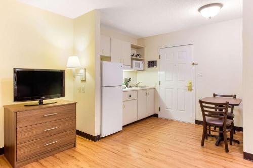 a kitchen with a refrigerator and a table with a chair at Studio 6 Myrtle Beach, SC in Myrtle Beach