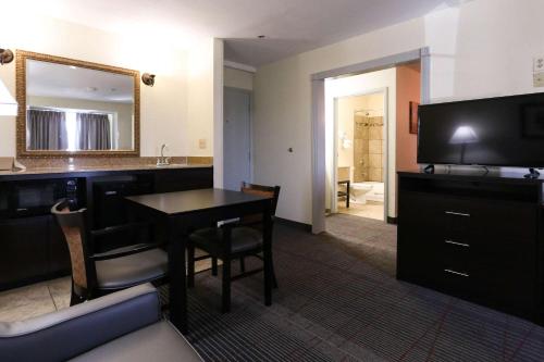 a living room with a table and a mirror at Econo Lodge Inn & Suites in Greenville