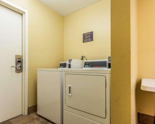 a small kitchen with a refrigerator and a sign on the wall at Quality Inn Mt. Pleasant – Charleston in Charleston