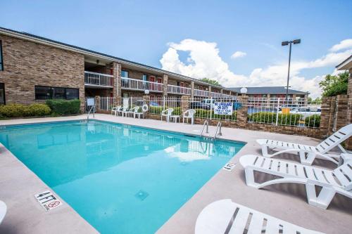 a swimming pool with chairs and a hotel at Rodeway Inn Expo Center in Spartanburg