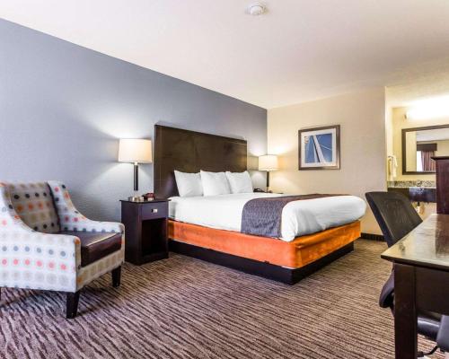 チャールストンにあるQuality Inn Mt Pleasant - Charlestonのベッドと椅子付きのホテルルーム