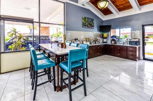 a large kitchen with a table and blue chairs at Rodeway Inn North Charleston - Ashley Phosphate in Charleston