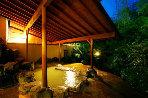 a patio with a pond with a wooden roof at Mount View Hakone in Hakone