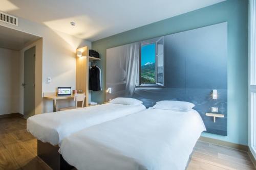 2 letti in una camera d'albergo con finestra di B&B HOTEL ANNEMASSE Saint-Cergues a Saint-Cergues