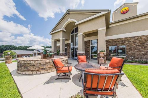 a patio with chairs and a table in front of a building at Comfort Inn & Suites Greenwood near University in Greenwood