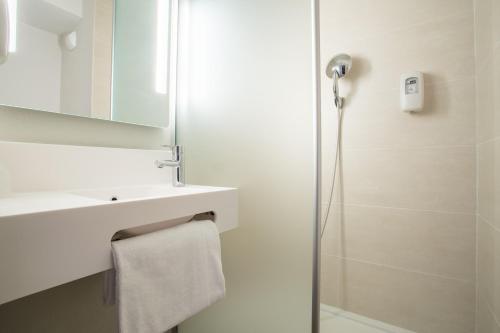 een badkamer met een douche, een wastafel en een spiegel bij B&B HOTEL ANNEMASSE Saint-Cergues in Saint-Cergues