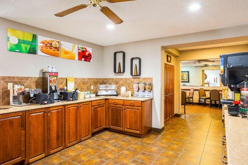 a kitchen with wooden cabinets and a counter top at Quality Inn Mitchell I-90 in Mitchell