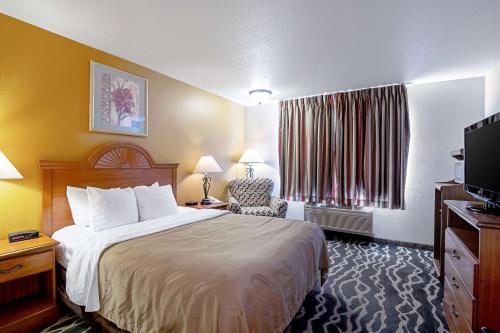 una habitación de hotel con una cama y un televisor en Quality Inn Huron, en Huron