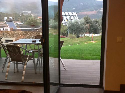 an open door to a patio with a table and chairs at Bosque da Harmonia in Arco de Baúlhe