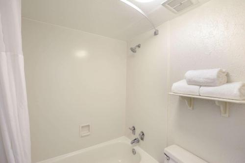 a white bathroom with a tub and a sink at Quality Inn & Suites North Charleston - Ashley Phosphate in Charleston