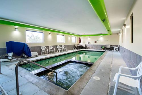 a swimming pool with chairs and a table at Quality Inn Aberdeen in Aberdeen