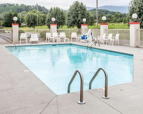 a large swimming pool with white chairs and tables at Econo Lodge Newport West in Newport