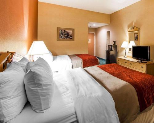 a hotel room with two beds and a flat screen tv at Econo Lodge Newport West in Newport