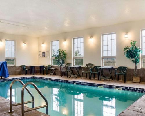 a swimming pool with tables and chairs in a building at Quality Inn Oacoma - Chamberlain in Oacoma