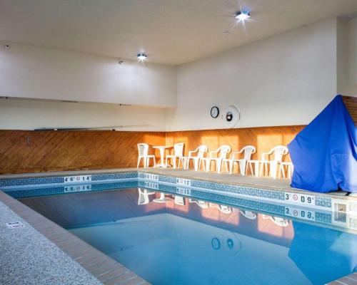 a swimming pool with stools in a building at Quality Inn Brandon - Sioux Falls in Brandon