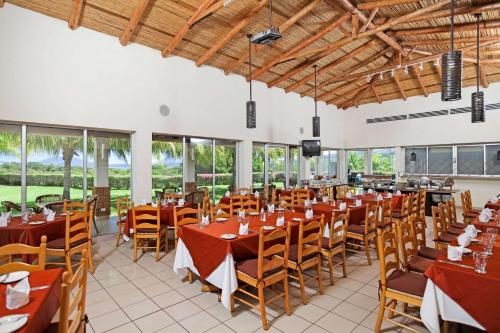 - une salle à manger avec des tables, des chaises et des fenêtres dans l'établissement Comfort Inn Real La Union, à La Unión